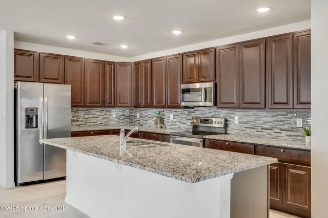 a kitchen with stainless steel appliances granite countertop a sink stove and refrigerator