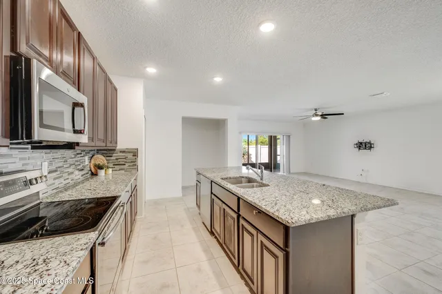 a kitchen with a stove sink and cabinets