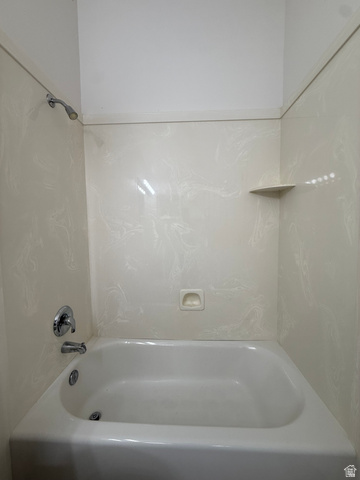 838 East Mountain Road Logan, UT 84321 - Photo 19 of 37 White porcelain bathtub with chrome fixtures and light-toned, patterned wall surround