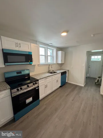 a kitchen with granite countertop a sink cabinets and stainless steel appliances
