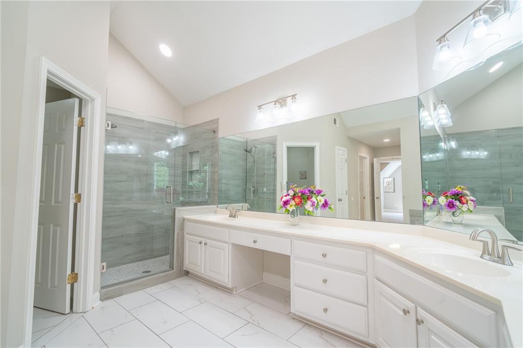 3819 Meandering Way Southwest Lilburn, GA 30047 - Photo 17 of 27 a bathroom with a sink mirror and a shower