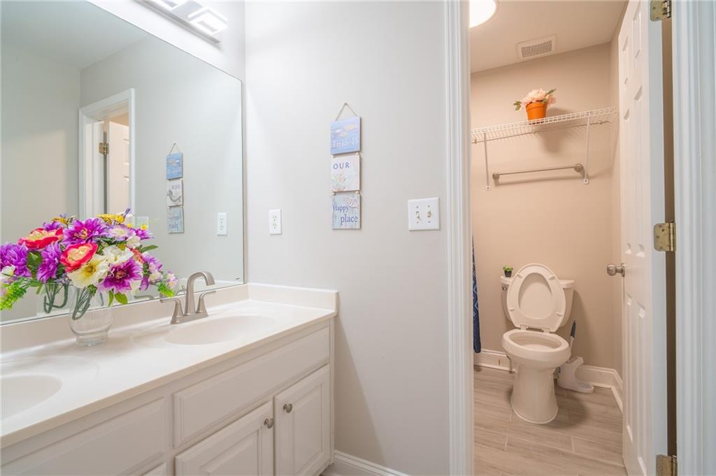 3819 Meandering Way Southwest Lilburn, GA 30047 - Photo 18 of 27 a bathroom with a sink vanity mirror and toilet
