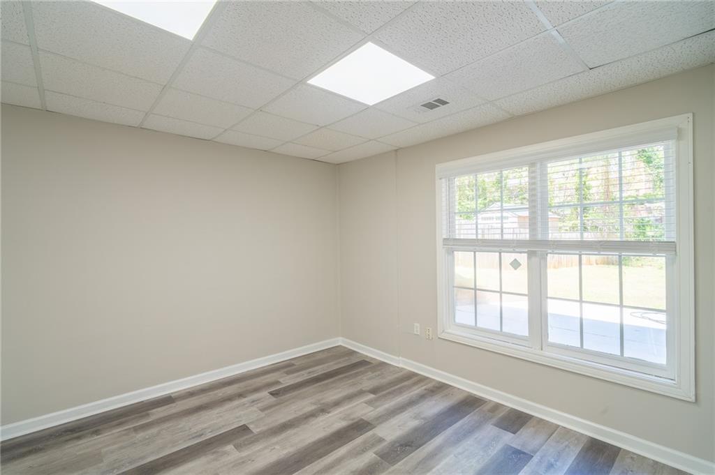 3819 Meandering Way Southwest Lilburn, GA 30047 - Photo 24 of 27 an empty room with wooden floor and windows