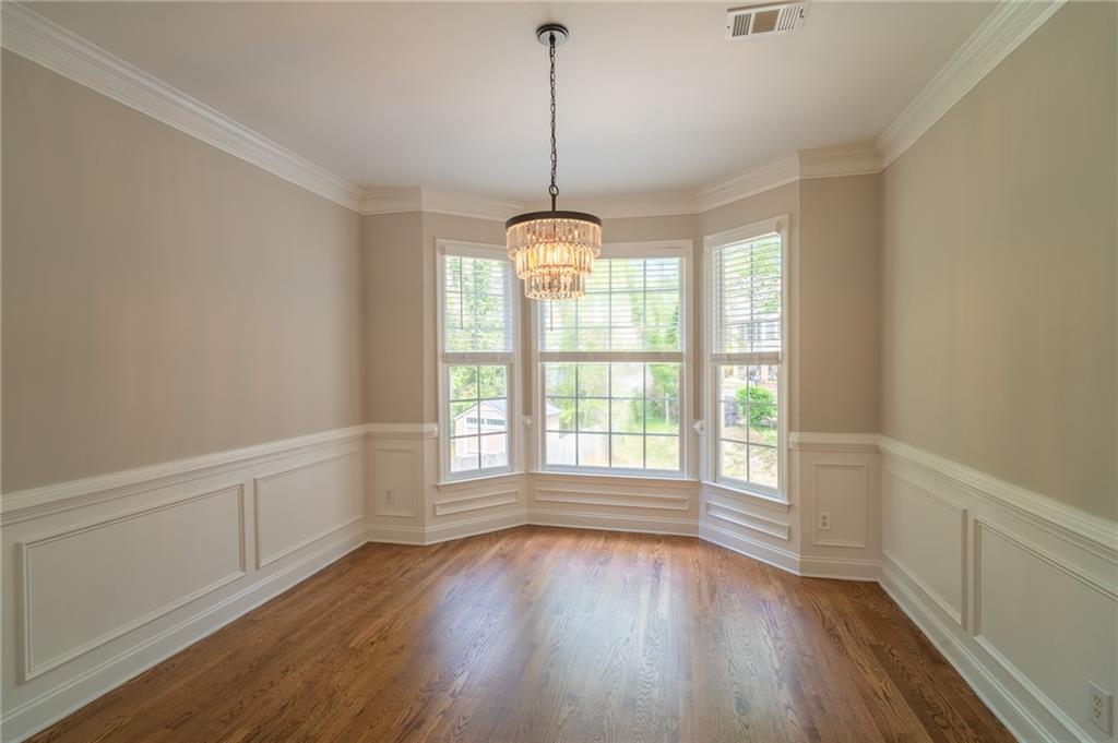 3819 Meandering Way Southwest Lilburn, GA 30047 - Photo 6 of 27 a view of a room with wooden floor windows and a ceiling fan
