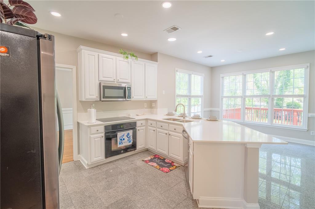 3819 Meandering Way Southwest Lilburn, GA 30047 - Photo 8 of 27 a kitchen with granite countertop stainless steel appliances a stove sink and microwave