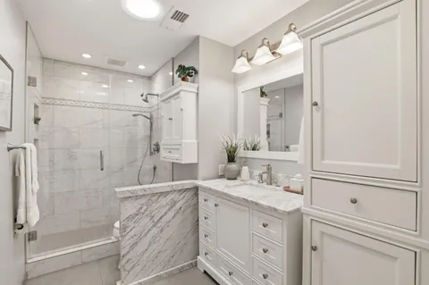 a bathroom with a double vanity sink mirror and shower