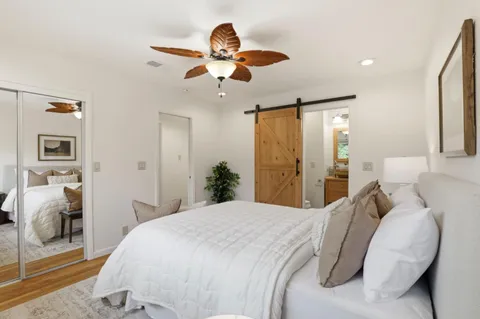 a bedroom with a large bed and ceiling fan
