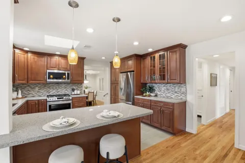 a kitchen with stainless steel appliances granite countertop a stove refrigerator and a stove