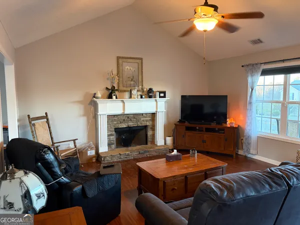 a living room with furniture a flat screen tv and a fireplace