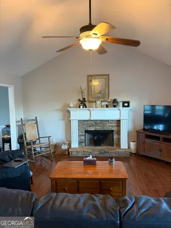a living room with furniture a flat screen tv and kitchen view