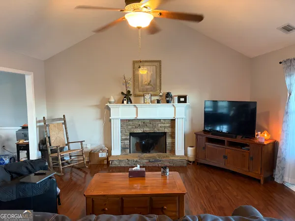 a living room with furniture a flat screen tv and a fireplace