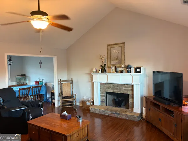 a living room with furniture a flat screen tv and a fireplace