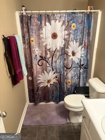 a bathroom with a toilet and shower curtain