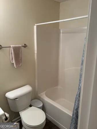 a white toilet sitting next to a bath tub
