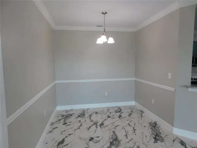 a view of a hallway with wooden floor and a chandelier