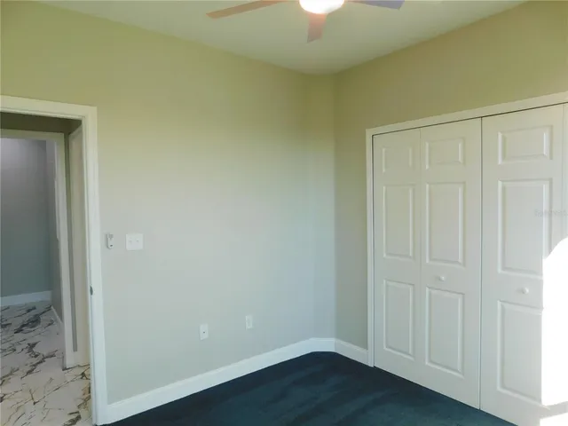 an empty room with wooden floor and closet area