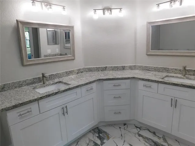 a bathroom with a granite countertop sink and mirror