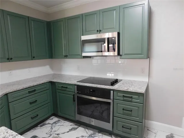 a kitchen with stainless steel appliances granite countertop a sink and a microwave