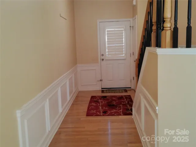 a view of a hallway with wooden floor and staircase