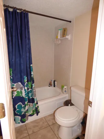 a white toilet sitting next to a bathroom sink and a tub