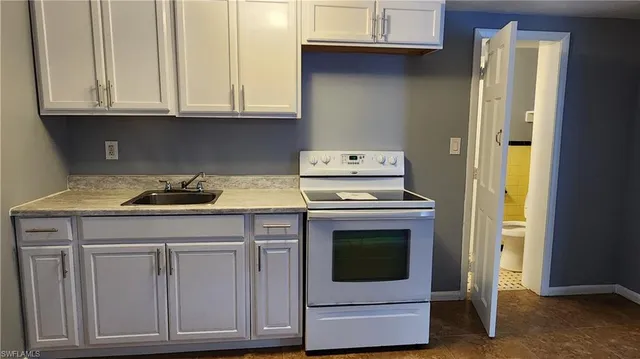 a kitchen with granite countertop white cabinets and white appliances