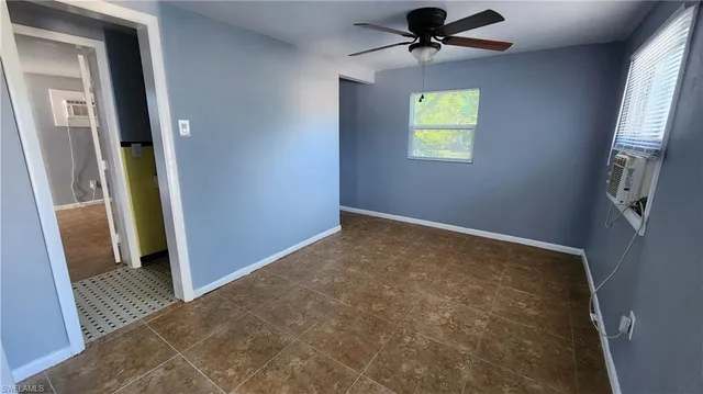 an empty room with windows and a ceiling fan