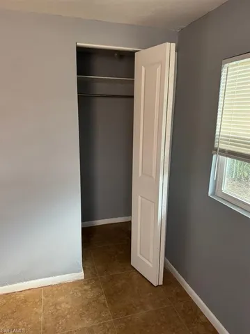 an empty room with windows and closet