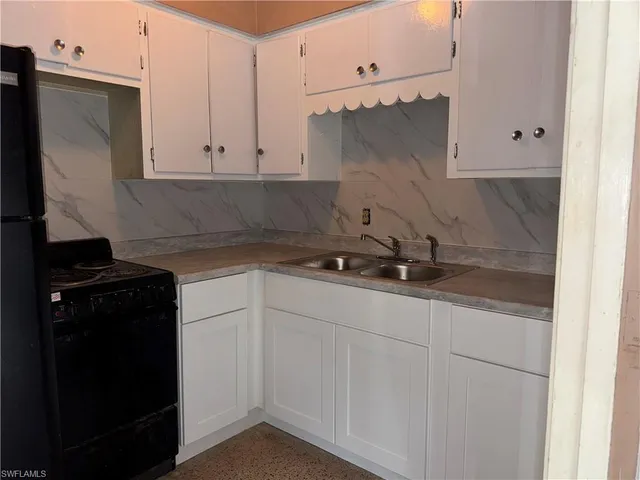 a kitchen with white cabinets and a sink