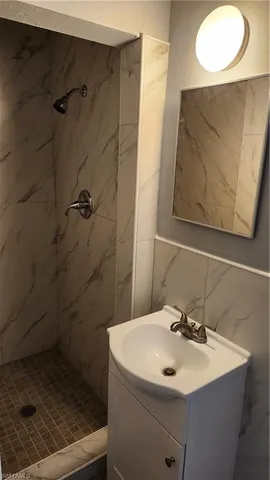 a bathroom with a sink mirror and shower