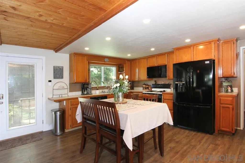 800 South Grade Road Alpine, CA 91901 - Photo 7 of 25 a kitchen with a table chairs refrigerator and microwave