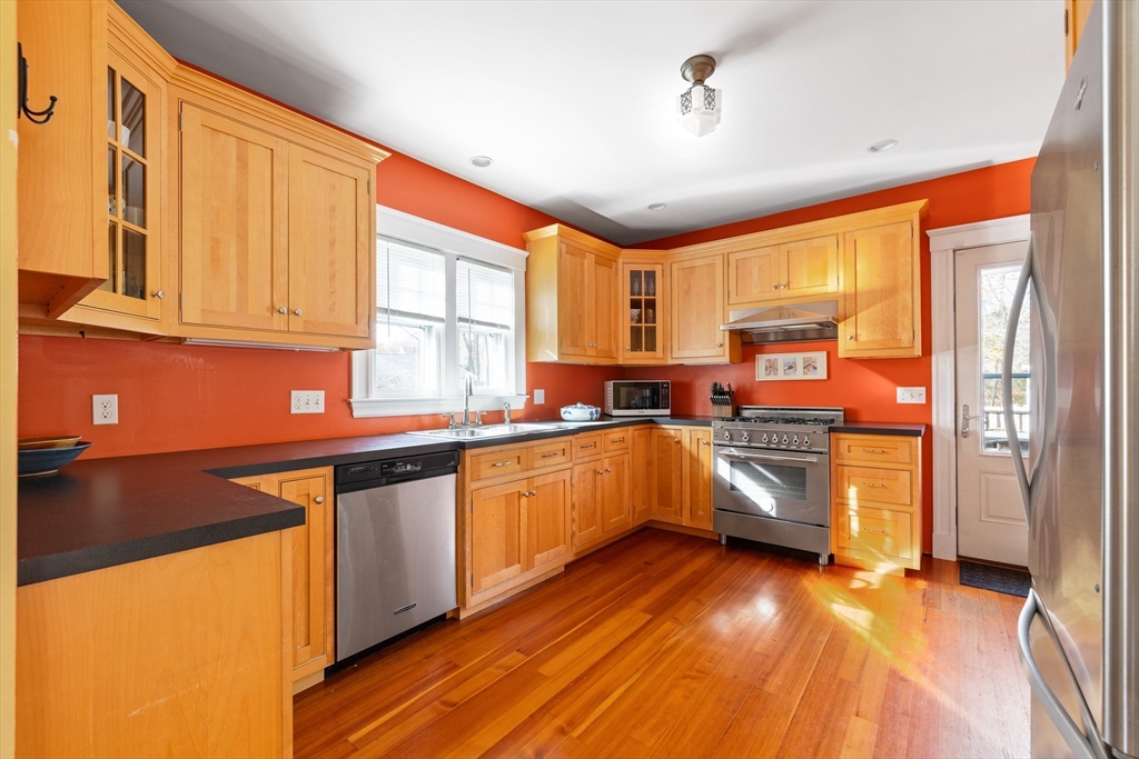 20 Marion Street Natick, MA 01760 - Photo 4 of 39 a kitchen with stainless steel appliances granite countertop a stove a sink and white cabinets with wooden floor