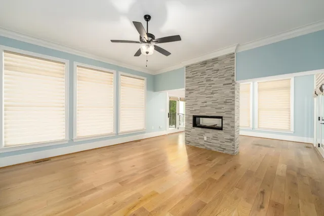 a view of an empty room with a window and wooden floor