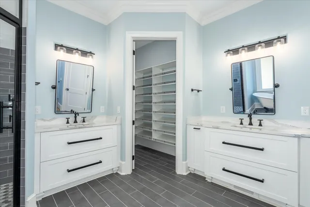 a bathroom with a double vanity sink a toilet and shower