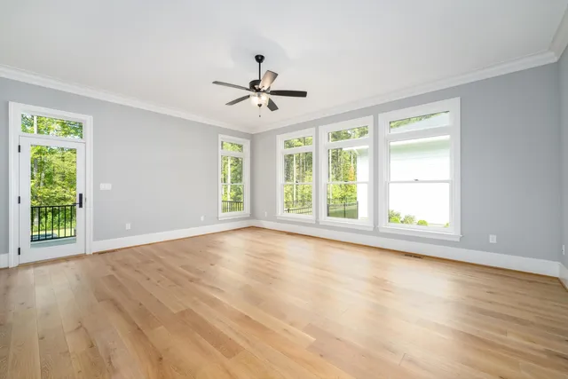 an empty room with wooden floor and window