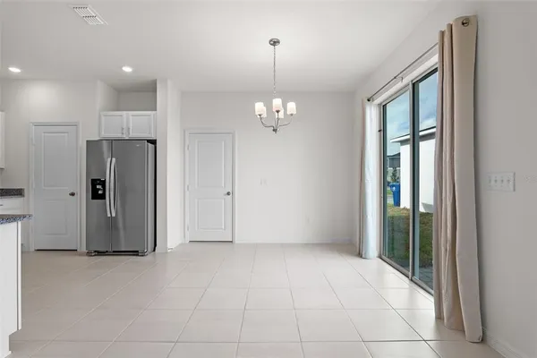 a view of a hallway with chandelier and glass door