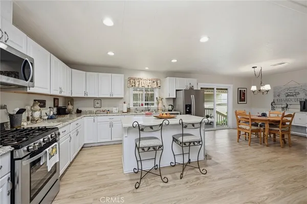 a kitchen with a dining table chairs and stainless steel appliances