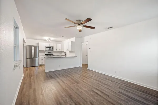 a view of kitchen with wooden floor refrigerator and window