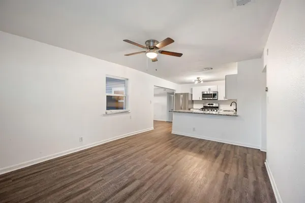 a view of a kitchen with wooden floor and a ceiling fan