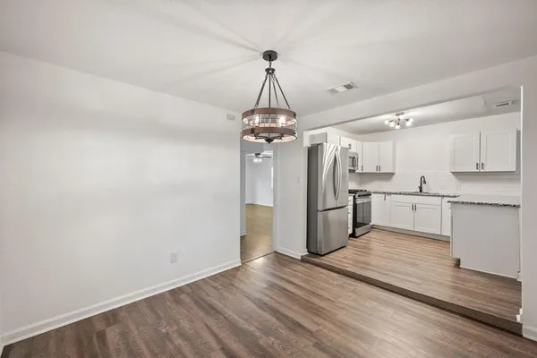 a view of a kitchen with wooden floor and a window