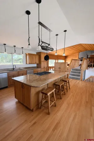 a kitchen with stainless steel appliances granite countertop a stove a sink and a wooden floors