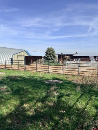 a view of swimming pool with lawn chairs and iron fence