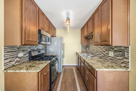 a kitchen with stainless steel appliances granite countertop a stove and a sink