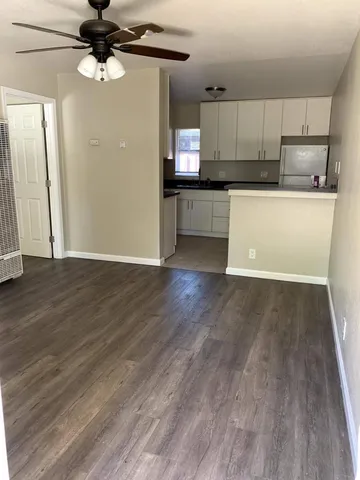 a view of a kitchen with a sink and wooden floor