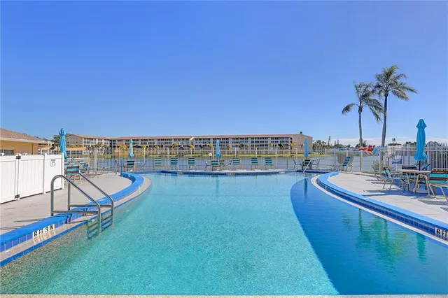 a view of a swimming pool with outdoor seating and a yard