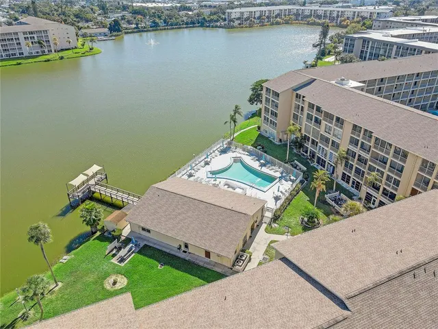 an aerial view of a house with a garden and lake view