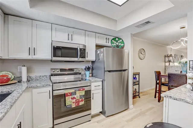 a kitchen with stainless steel appliances granite countertop a refrigerator stove and sink