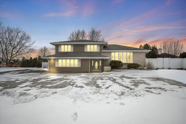 a view of a house with a yard covered in snow