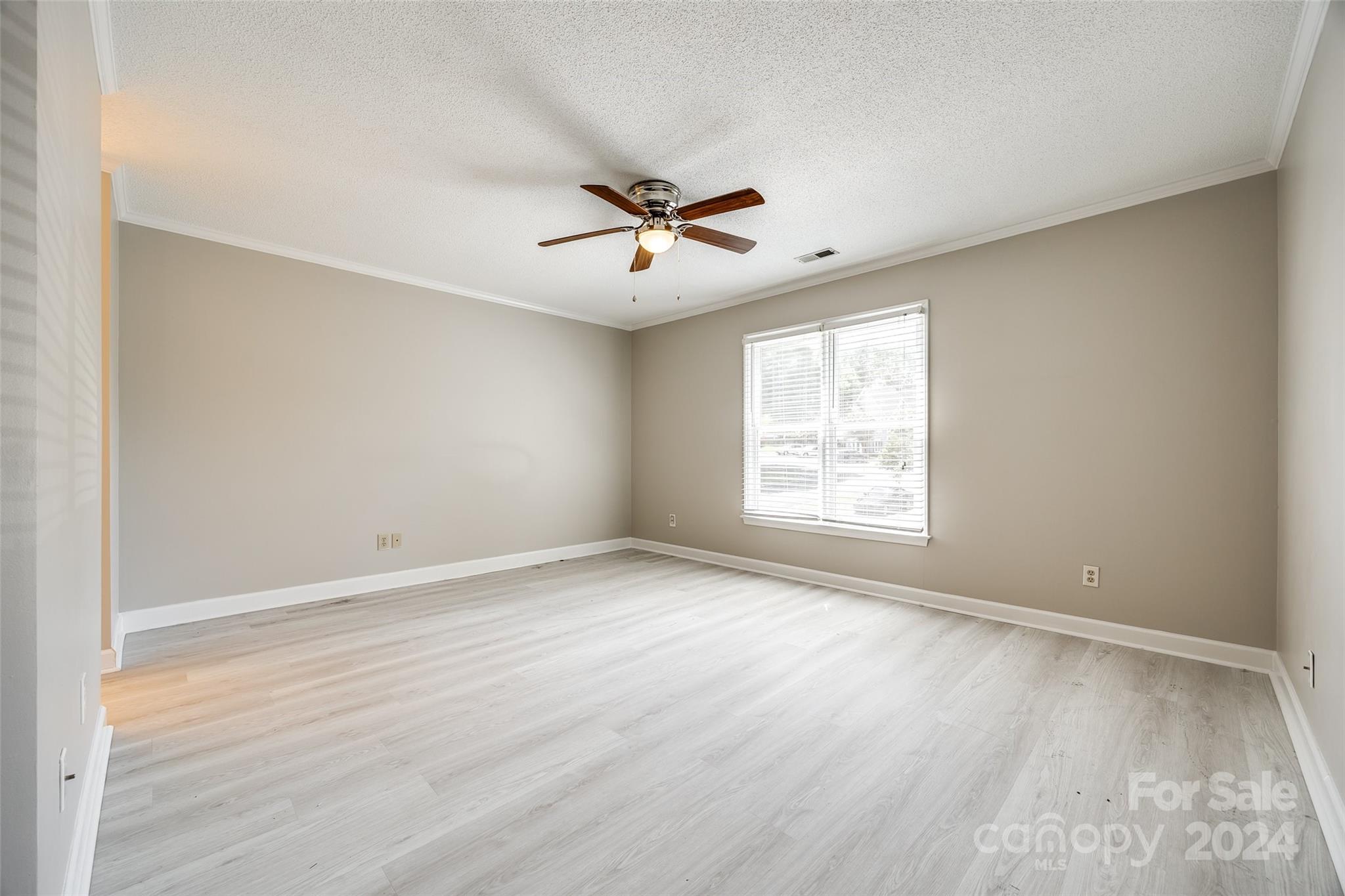 1711 Robinwood Road Gastonia, NC 28054 - Photo 19 of 25 an empty room with wooden floor ceiling fan and windows