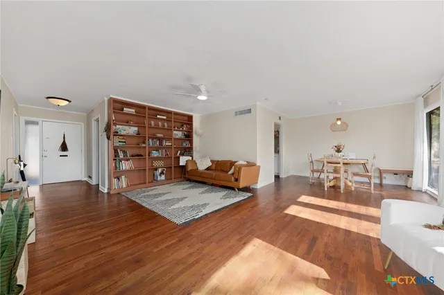 a living room with furniture and a wooden floor