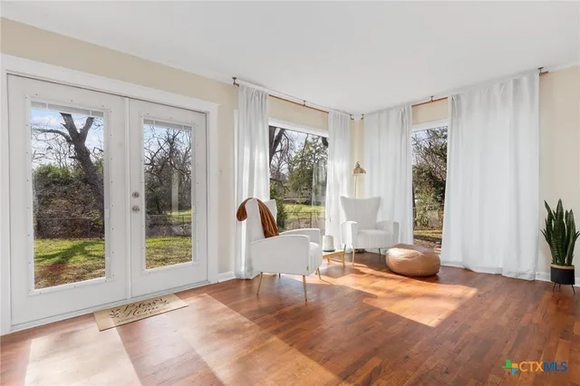 a view of a livingroom with wooden floor and furniture